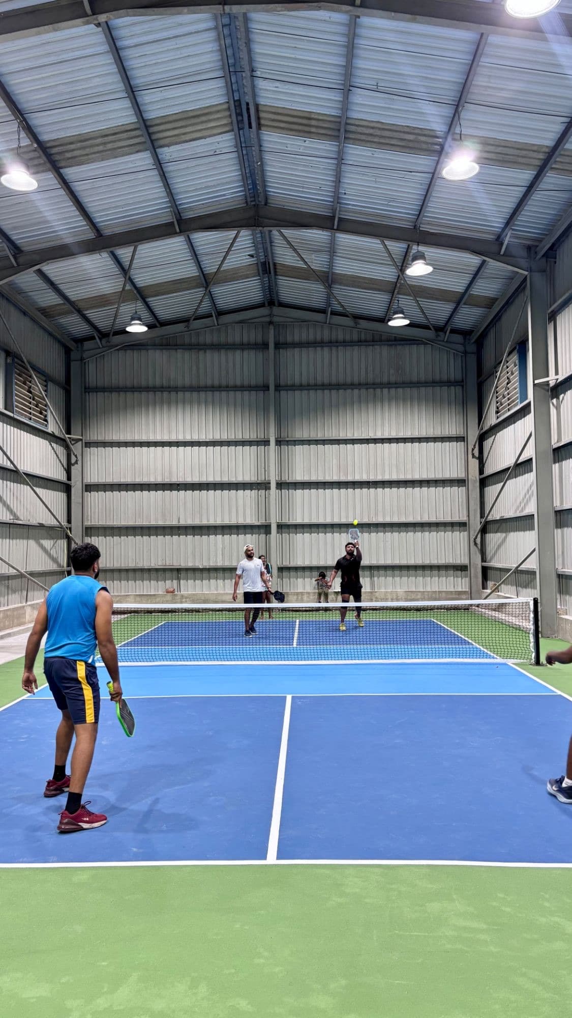 Players mid-rally on an indoor court at PIQL in Kandana