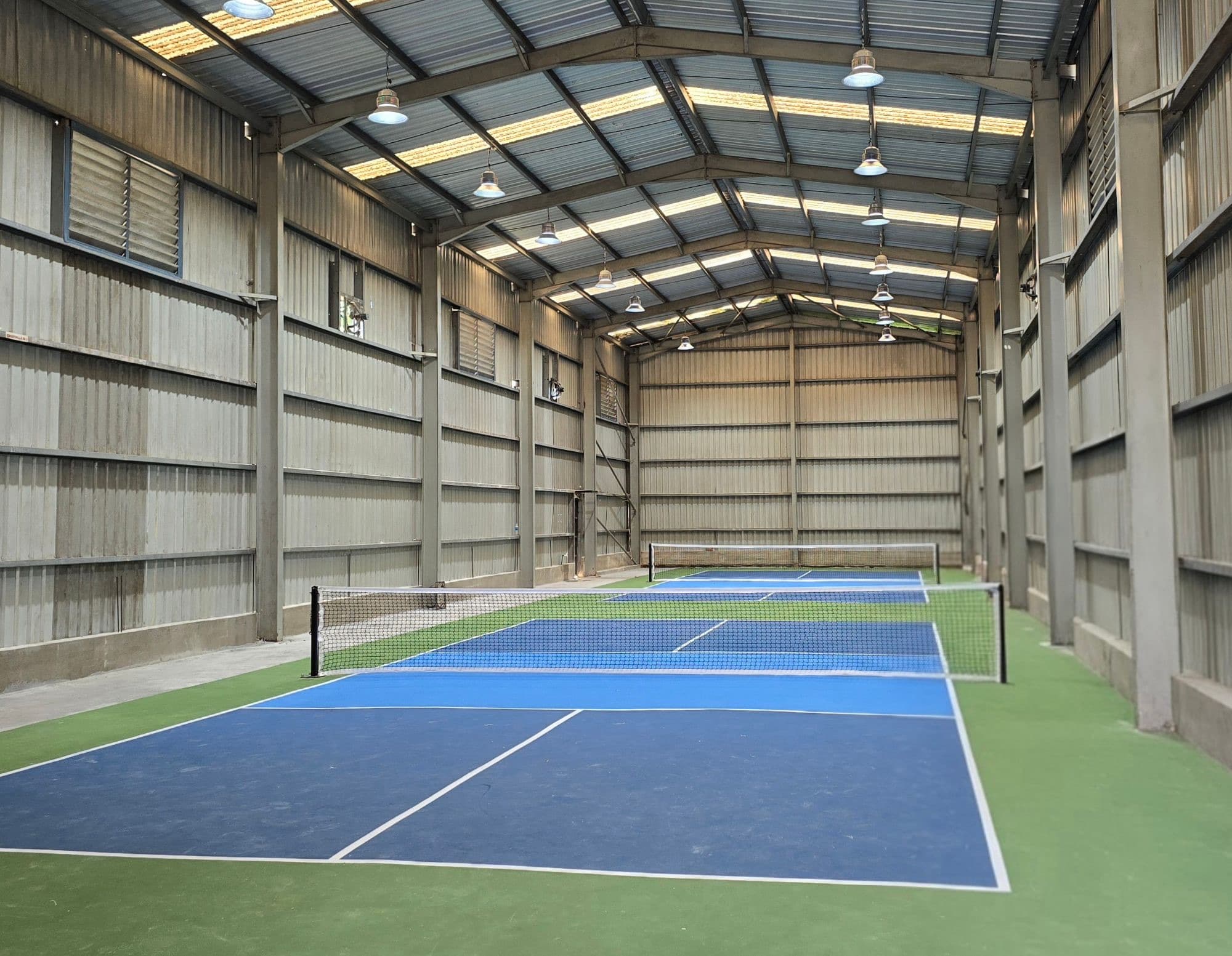 The two indoor pickleball courts at PIQL, Kandana, under a steel roof